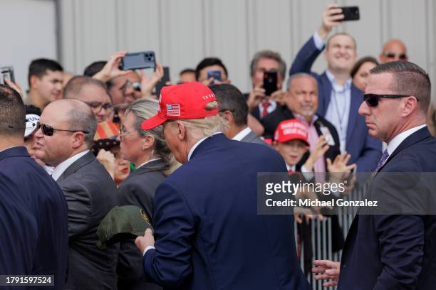 Former President Donald Trump signs a Border Patrol hat after giving remarks at the South Texas International airport on November 19, 2023 in...