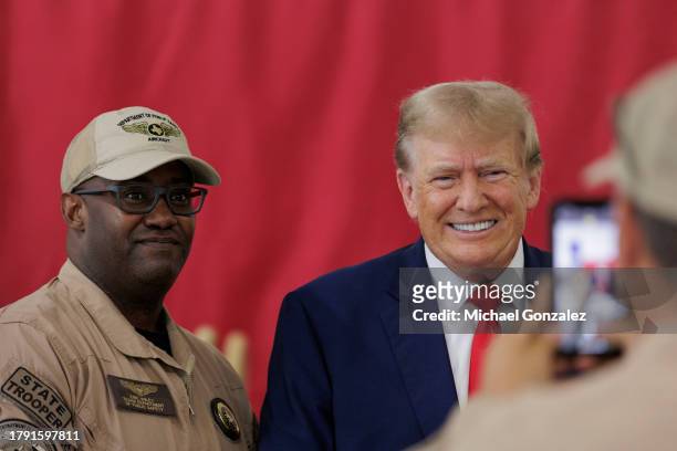 Former President Donald Trump poses for a photo with a member of the Texas Department of Public Safety at the South Texas International airport on...