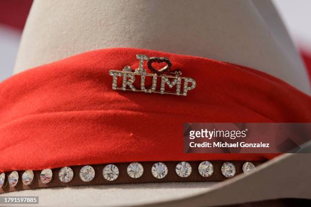 Supporter of former President Donald Trump wears a "I love Trump" pin on a cowboy hat after he gives remarks at the South Texas International airport...