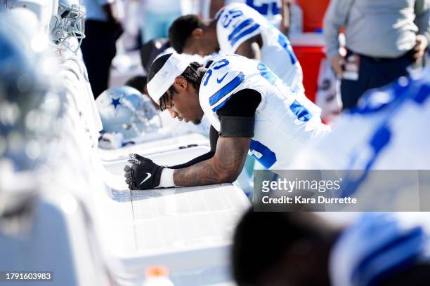 Damone Clark of the Dallas Cowboys prays prior to an NFL football game against the Carolina Panthers at Bank of America Stadium on November 19, 2023...