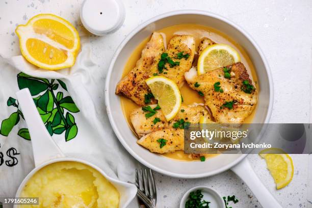 fillet of white fish in butter lemon sauce - aliment préparé en filet photos et images de collection