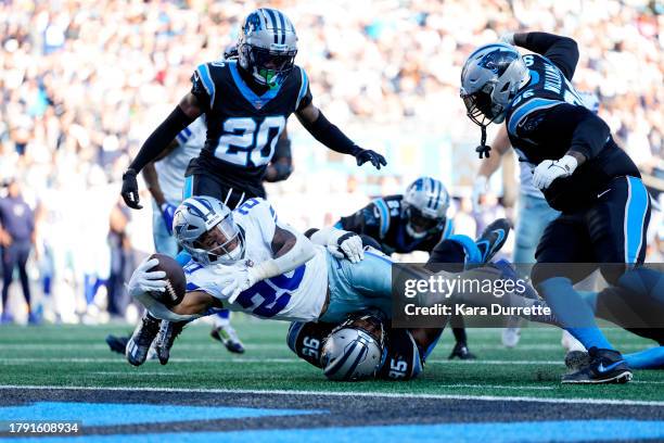 Tony Pollard of the Dallas Cowboys reaches into the end zone for a touchdown as Derrick Brown of the Carolina Panthers defends during an NFL football...