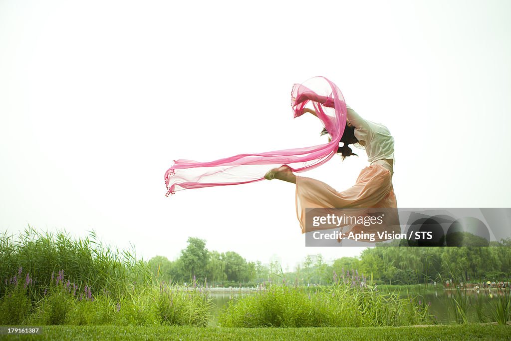 Young woman dancing on grass