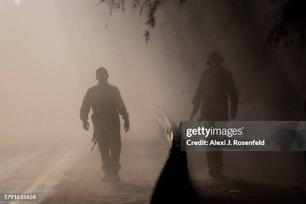 The silhouette of IDF soldiers walking through a cloud of sand and dust in an area near the Gaza border on November 13, 2023 in Southern Israel. More...