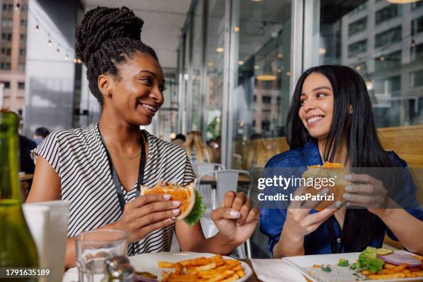 women in business enjoying lunch break together - hamburger stockfoto's en -beelden
