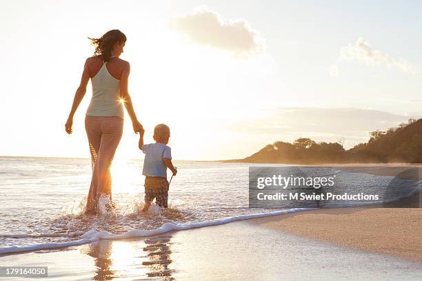 mother and child - mother and child in water at beach stock pictures, royalty-free photos & images