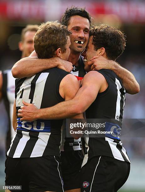 Alan Didak of the Magpies is congratulated by team mates after kicking a goal during the round 23 AFL match between the Collingwood Magpies and the...