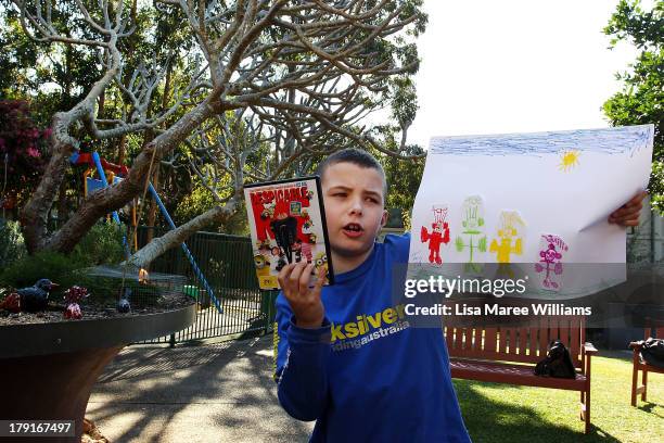 Tony Abbott fan Ben Betteridge holds up his drawing to the media at Bear Cottage in Sydney on September 1, 2013 in Sydney, Australia. Australian...