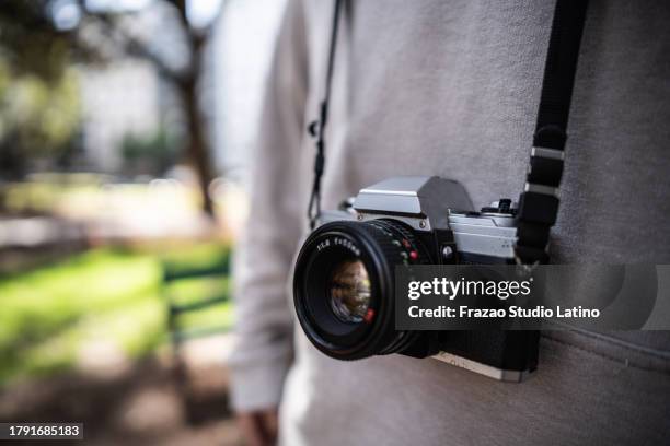 photographic camera on someone's neck - mirrorless camera stock pictures, royalty-free photos & images