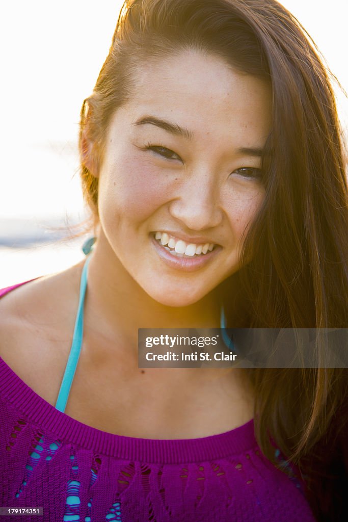 Beautiful woman at beach at sunset laughing