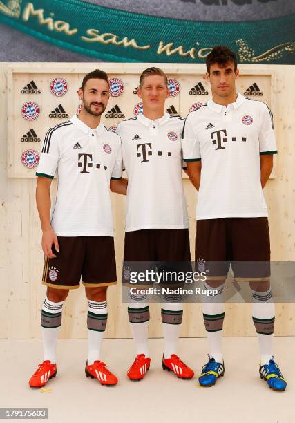 Diego Contento, Bastian Schweinsteiger and Javi Martinez of FC Bayern Muenchen present their new trikot in bavarian style at Saebener Strasse...