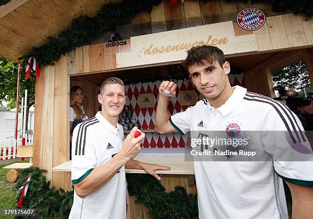 Javi Martinez and Bastian Schweinsteiger of FC Bayern Muenchen present their new trikot in bavarian style while playing Oktoberfest games at Saebener...