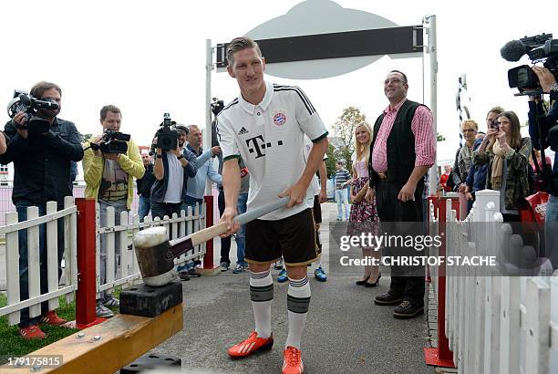 Bayern Munich's midfielder Bastian Schweinsteiger plays the traditional funfair game "Hau den Lukas" during the presentation of the new season...