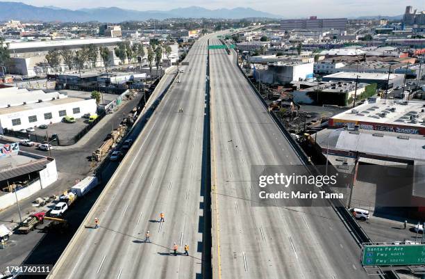 An aerial view of workers walking on the closed I-10 freeway following a large pallet fire , which occurred Saturday at a storage yard, on November...