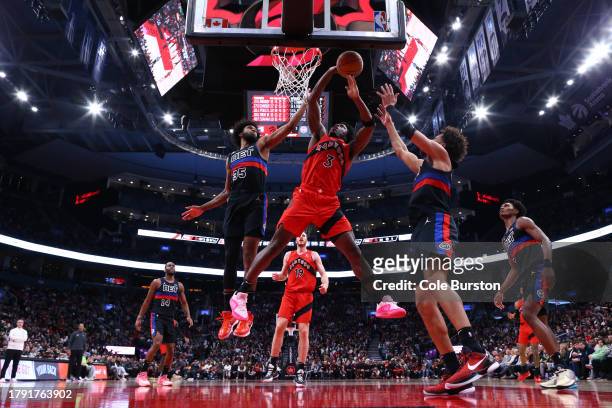 Anunoby of the Toronto Raptors is fouled at the basket as he goes up against Marvin Bagley III and Cade Cunningham of the Detroit Pistons during the...