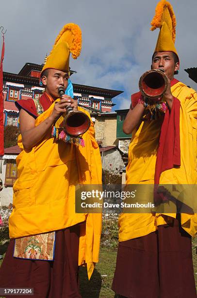 Yellow hat monks blowing horns at the Mani Rimdu Festival at Tengboche Monastery in the Everest Region of Nepal