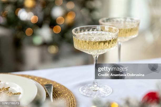 dos copas de champán en la mesa de navidad - copa de champán fotografías e imágenes de stock
