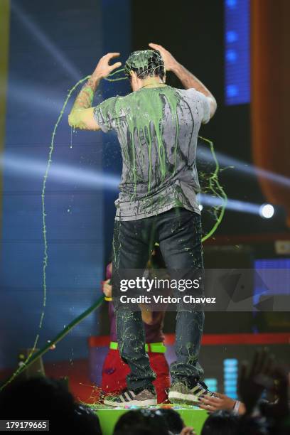 Host Jaime Camil speaks onstage after getting slimed during the Kids Choice Awards Mexico 2013 at Pepsi Center WTC on August 31, 2013 in Mexico City,...