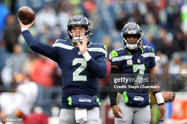 Drew Lock and Geno Smith of the Seattle Seahawks warm up before the game against the Washington Commanders at Lumen Field on November 12, 2023 in...