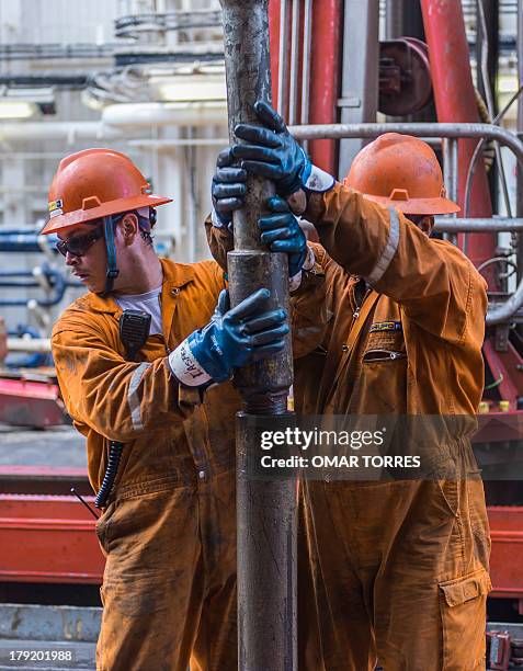Derrick hands remove the drilling tool with a sample of the marine seabed at La Muralla IV exploration oil rig, operated by Mexican company "Grupo R"...