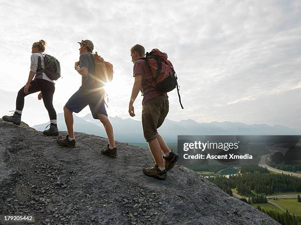 hikers climb ridge above sunrise, valley - people climbing walking mountain group stock pictures, royalty-free photos & images