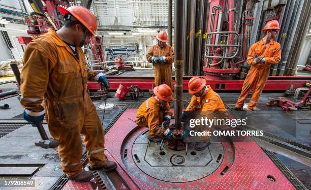 Derrick hands remove the drilling tool with a sample of the marine seabed at La Muralla IV exploration oil rig, operated by Mexican company "Grupo R"...