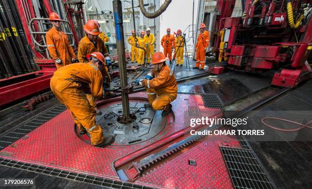 Derrick hands remove the drilling tool with a sample of the marine seabed at La Muralla IV exploration oil rig, operated by Mexican company "Grupo R"...