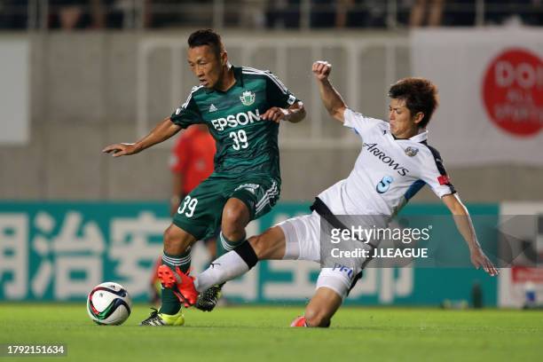 Yoshiro Abe of Matsumoto Yamaga is tackled by Shogo Taniguchi of Kawasaki Frontale during the J.League J1 second stage match between Matsumoto Yamaga...