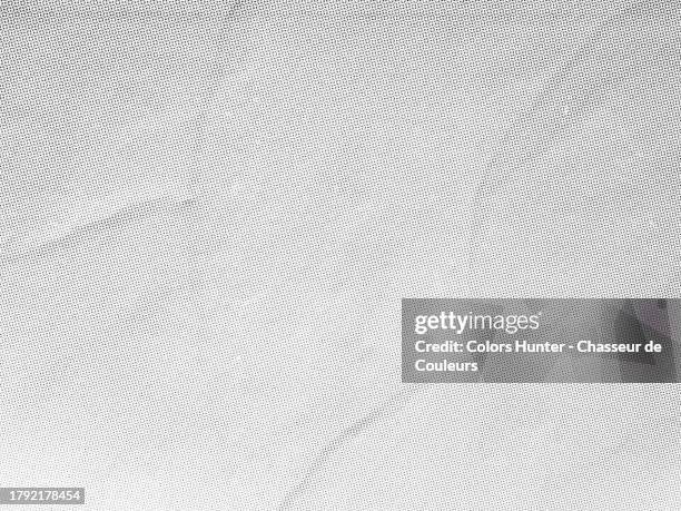 close-up of a white poster with a mesh of black and grey dots pasted onto a textured wall in paris, france - blank newspaper stock pictures, royalty-free photos & images