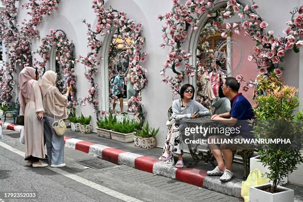 This photo taken on November 18, 2023 shows visitors taking photos in the Old Town in the southern Thai island of Phuket.