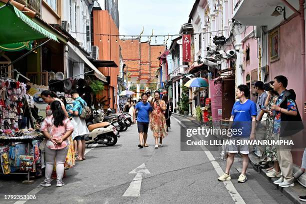 This photo taken on November 18, 2023 shows visitors walking in the Old Town in the southern Thai island of Phuket.