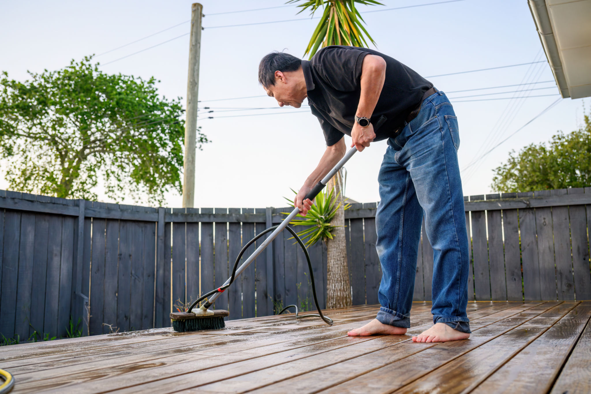 man pressure washing deck