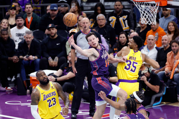 Drew Eubanks of the Phoenix Suns attempts to control an offensive rebound against Christian Wood of the Los Angeles Lakers and LeBron James during...