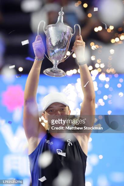 Iga Swiatek of Poland celebrates with the Billie Jean King Trophy after defeating Jessica Pegula of the United States in the singles final on the...