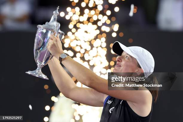 Iga Swiatek of Poland celebrates with the Billie Jean King Trophy after defeating Jessica Pegula of the United States in the singles final on the...