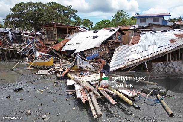 This photo taken on November 19, 2023 shows a resident inspecting his destroyed house in the town of Glan, Sarangani province, after a 6.7-magnitude...