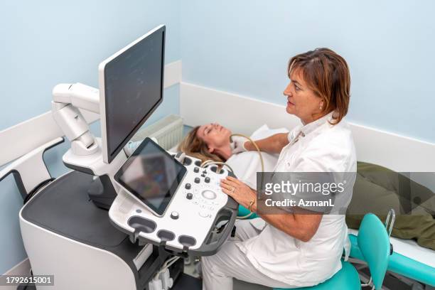 caucasian sonographer performs thyroid ultrasound exam - throat exam 個照片及圖片檔