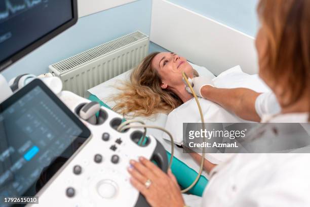 mittlerer erwachsener kaukasischer frau bei ultraschalluntersuchung - throat exam stock-fotos und bilder