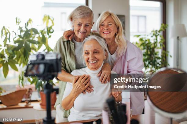 cheerful senior influencer women making live video for social media. cool elderly granfluencers creating online content at home in living room. live broadcasting, seniors sharing their lives openly on internet to followers. - fashionable grandma stock pictures, royalty-free photos & images