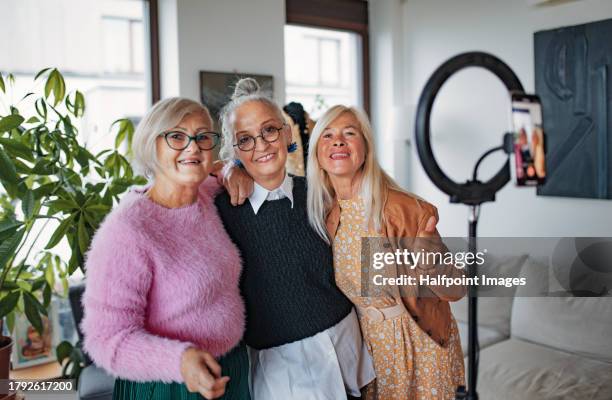 cheerful senior influencer women making live video for social media. cool elderly granfluencers creating online content at home in living room. live broadcasting, seniors sharing their lives openly on internet to followers. - fashionable grandma stock pictures, royalty-free photos & images