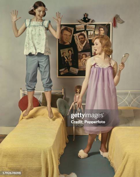 Posed studio portrait of two teenage girls wearing, on left, short legged pyjamas and smock top and, on right, a baby doll style night dress, they...