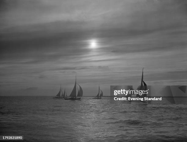 Sailing boats on the water at dusk during the Cowes Week sailing regatta, Cowes, Isle of Wight, August 1958.