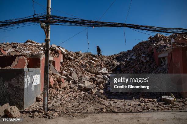 Woman collects scrap metal among demolished buildings in Yuxinzhuang village in Beijing, China, on Friday, Nov. 17, 2023. China home prices fell the...