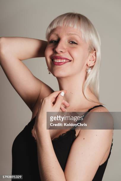 smiling transgender woman with short blonde hair and snowflake earrings - glamour live show fashion shows stock pictures, royalty-free photos & images