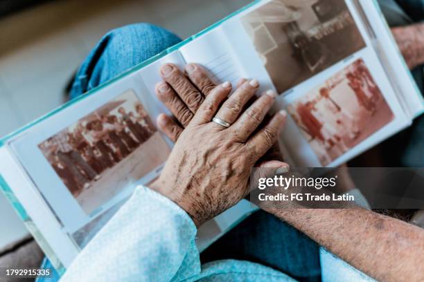 nahaufnahme von paarhänden auf einem fotoalbum - fotoalbum stock-fotos und bilder