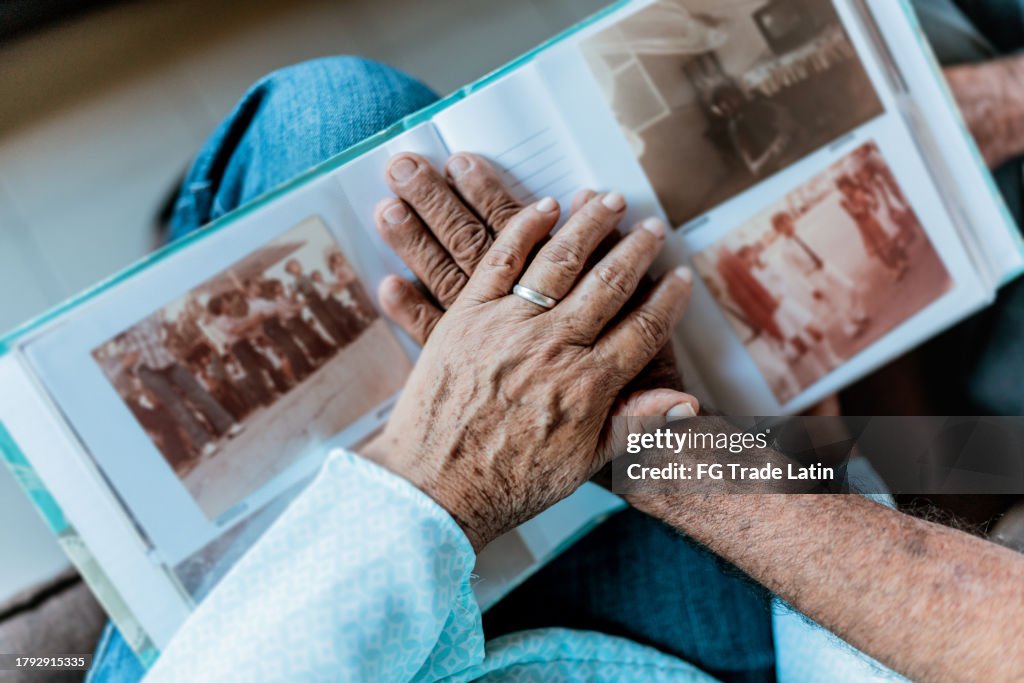 Close-up of couple hands on top of a photo album