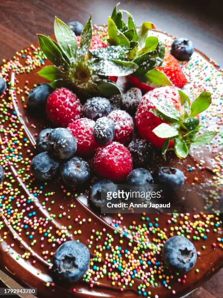 chocolate birthday cake with lots of fresh fruit on top - plant part stock pictures, royalty-free photos & images