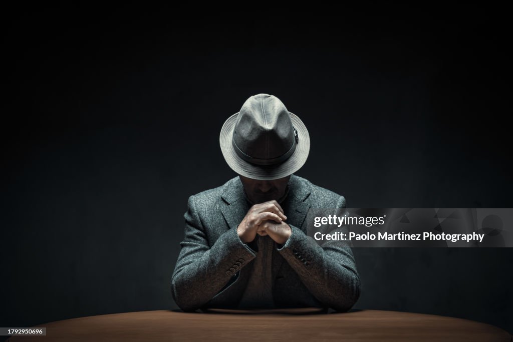Mystery man sitting at table in a dark room