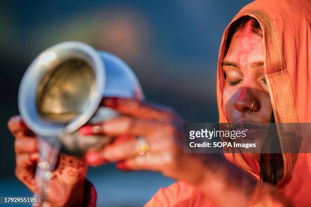 Nepalese Hindu woman makes offerings to the rising Sun God as she concludes the Chhath festival on the bank of the holy Bagmati river during the...