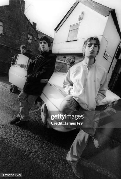 Group portrait of British rock band Oasis leaning against a Jaguar XJ6 car in Withington, Manchester, United Kingdom, 30th November 1993. L-R Paul...